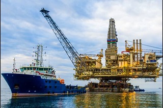 A ship and an oil rig platform in the ocean