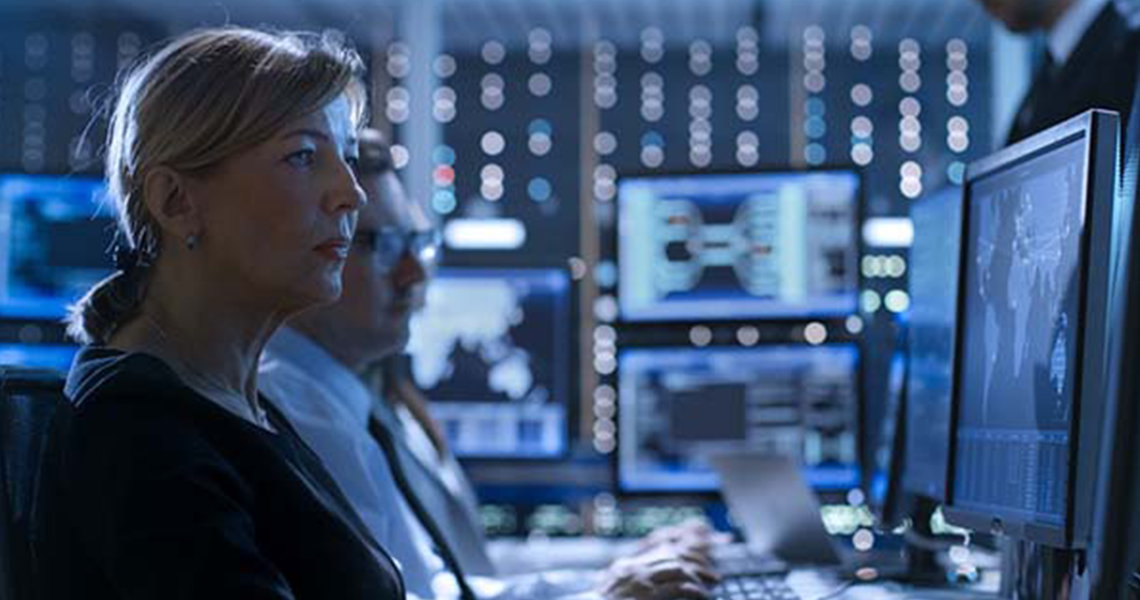 Man and woman working at their desktops in a server room