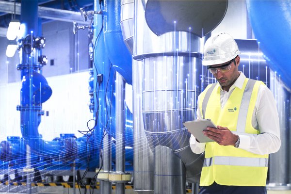 Johnson Controls technician using a tablet and inspecting HVAC equipments