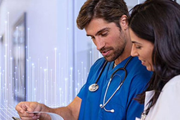 A male surgeon and a female doctor reading reports on a writing pad