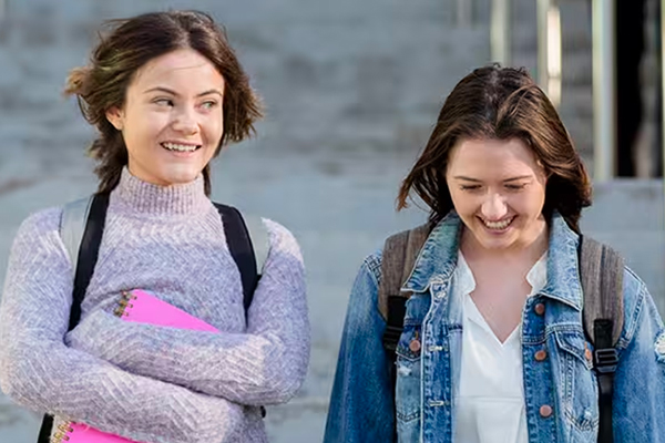 Two school girls walking and smiling