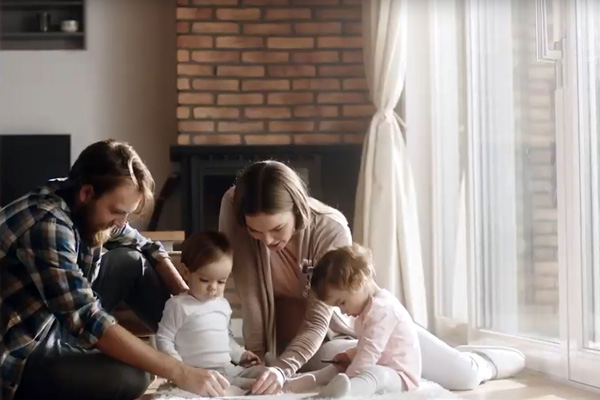 A couple with two young children, in a living room