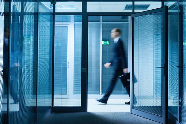 Motion-blur shot of a man walking through an office hallway